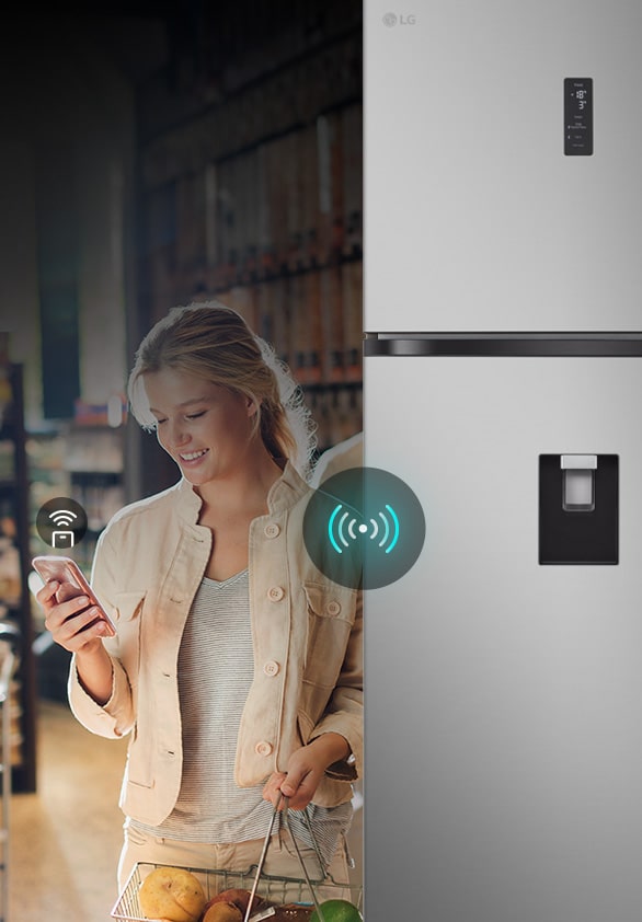 Woman using smartphone to remotely control LG refrigerator via LG ThinQ app